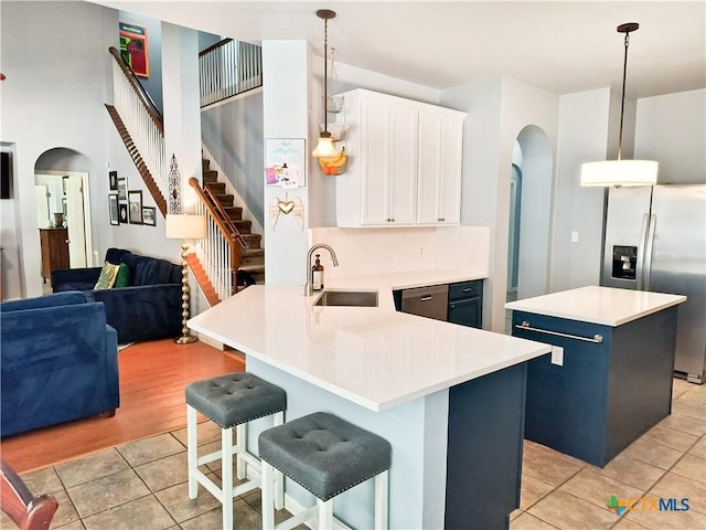 kitchen with a breakfast bar, a center island, white cabinetry, and hanging light fixtures