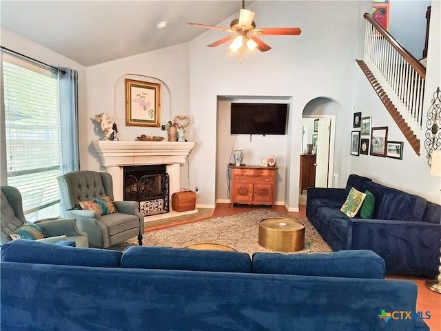 living room featuring hardwood / wood-style flooring, ceiling fan, and high vaulted ceiling