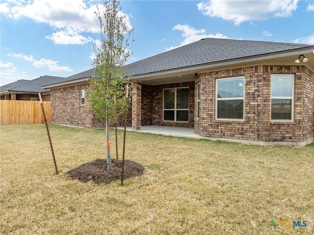 rear view of house featuring a yard and a patio