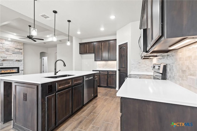 kitchen with sink, hanging light fixtures, appliances with stainless steel finishes, an island with sink, and ceiling fan