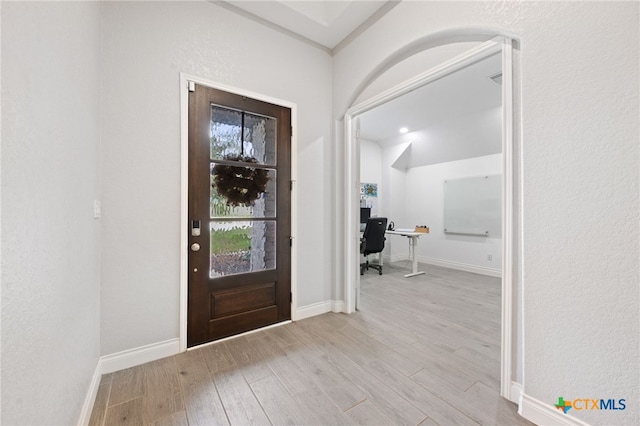 foyer featuring baseboards and wood finished floors
