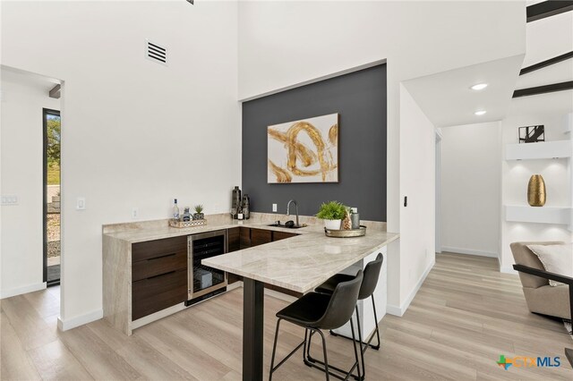 2637 Campestres, Spring Branch, TX 78070 - indoor wet bar with wine cooler, light wood-type flooring, baseboards, a high ceiling, and recessed lighting