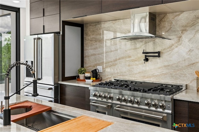 2637 Campestres, Spring Branch, TX 78070 - kitchen with range with two ovens, wall chimney range hood, refrigerator with ice dispenser, backsplash, and modern cabinets