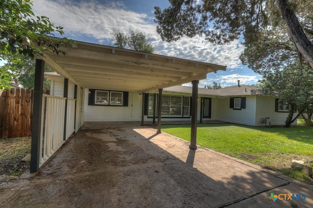 rear view of house with a carport and a lawn