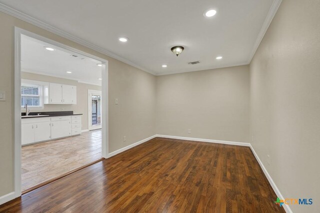 empty room with crown molding and dark hardwood / wood-style floors