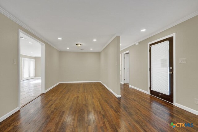 spare room with dark wood-type flooring and crown molding