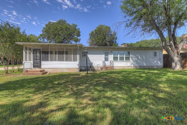 single story home featuring a sunroom and a front yard