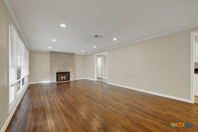 unfurnished living room featuring dark hardwood / wood-style flooring, crown molding, and a fireplace