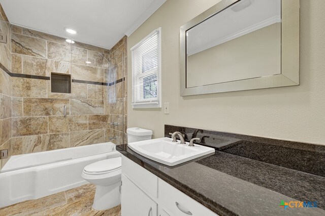 full bathroom with tiled shower / bath, vanity, and toilet