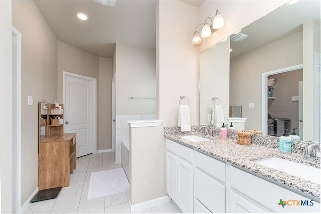 10207 Six Shooter Ln, Temple, TX 76502 - bathroom with marble finish floors, baseboards, double vanity, a bathtub, and recessed lighting