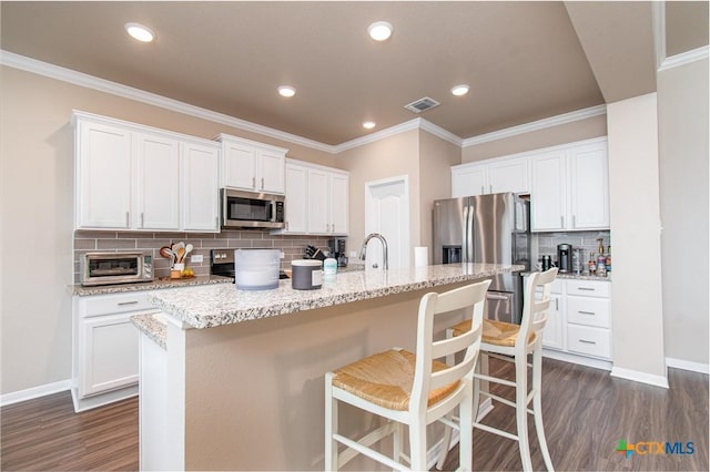 10207 Six Shooter Ln, Temple, TX 76502 - kitchen featuring stainless steel appliances, dark wood-type flooring, tasteful backsplash, a breakfast bar area, and ornamental molding
