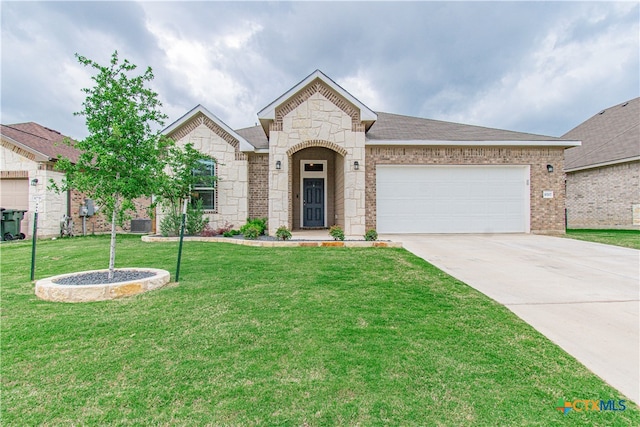 10207 Six Shooter Ln, Temple, TX 76502 - french country inspired facade with concrete driveway, a front yard, a garage, stone siding, and brick siding