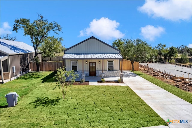 exterior space with a yard, fence, covered porch, and stone siding