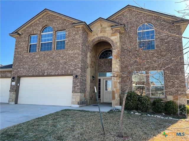 view of front of house featuring stone siding, brick siding, and driveway