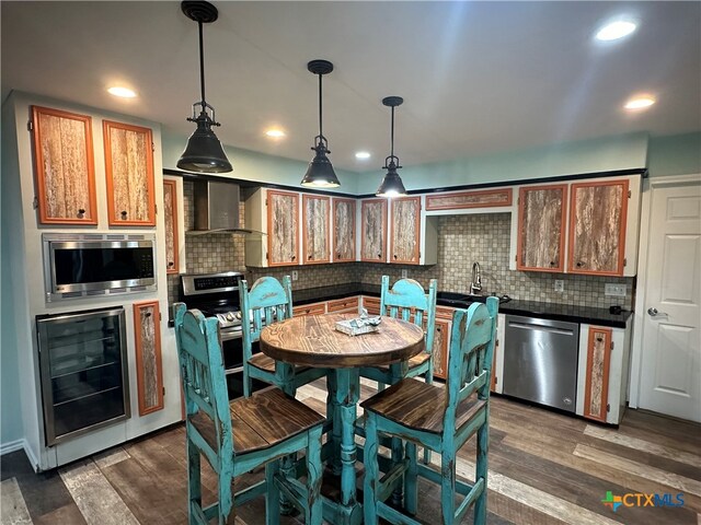 kitchen featuring stainless steel appliances, wine cooler, backsplash, dark hardwood / wood-style flooring, and hanging light fixtures