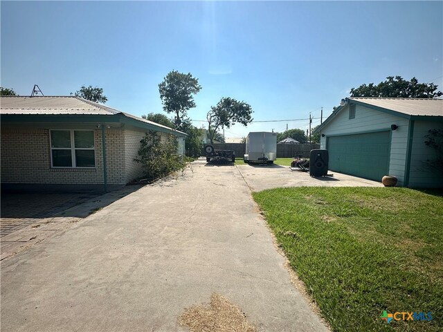 view of side of home with a garage, an outdoor structure, and a yard