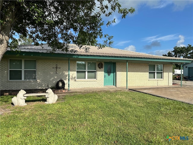 rear view of property featuring a patio and a yard