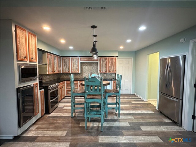 kitchen featuring wine cooler, appliances with stainless steel finishes, tasteful backsplash, decorative light fixtures, and dark wood-type flooring