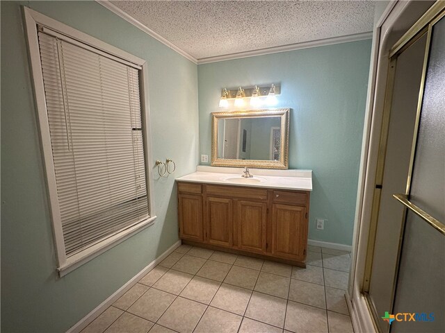 bathroom with vanity, a textured ceiling, tile patterned flooring, and ornamental molding