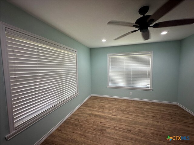 spare room featuring dark wood-type flooring and ceiling fan