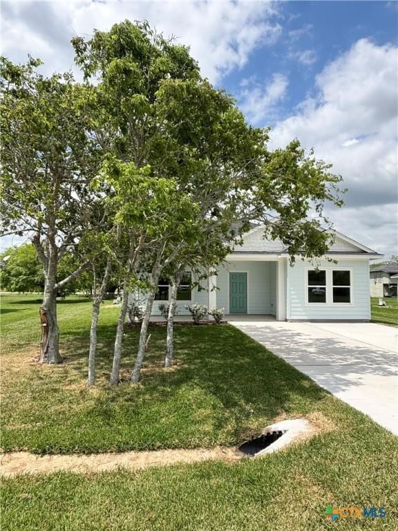view of front of home with concrete driveway and a front lawn