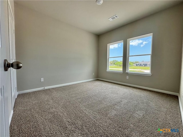 unfurnished room featuring visible vents, carpet flooring, and baseboards
