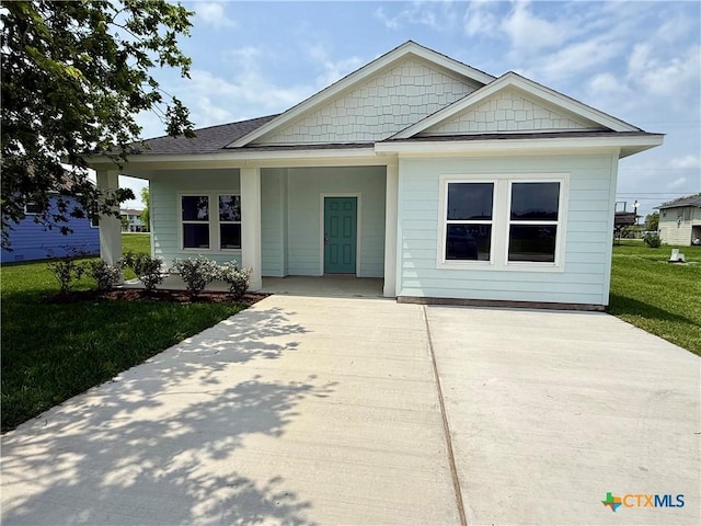 view of front of home with a porch, a front lawn, and driveway