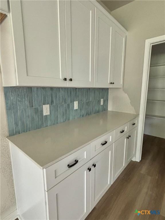 kitchen featuring backsplash, dark wood-style flooring, white cabinetry, and light countertops