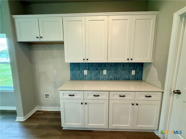 kitchen featuring baseboards, white cabinets, backsplash, and dark wood finished floors