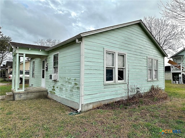 view of side of home with a yard