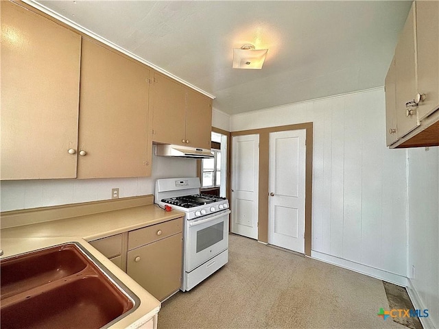 kitchen with light floors, light countertops, a sink, white range with gas stovetop, and under cabinet range hood