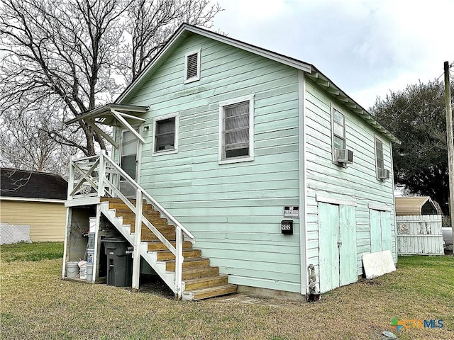 back of house featuring a yard, stairway, and fence