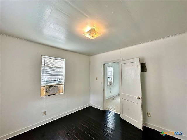 empty room with dark wood-type flooring, cooling unit, and baseboards