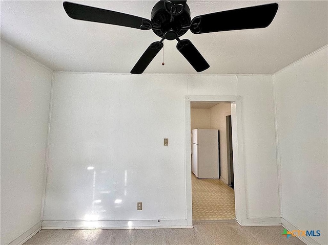 empty room featuring ceiling fan and baseboards