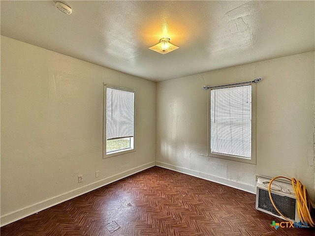 unfurnished room featuring a wall mounted AC and baseboards