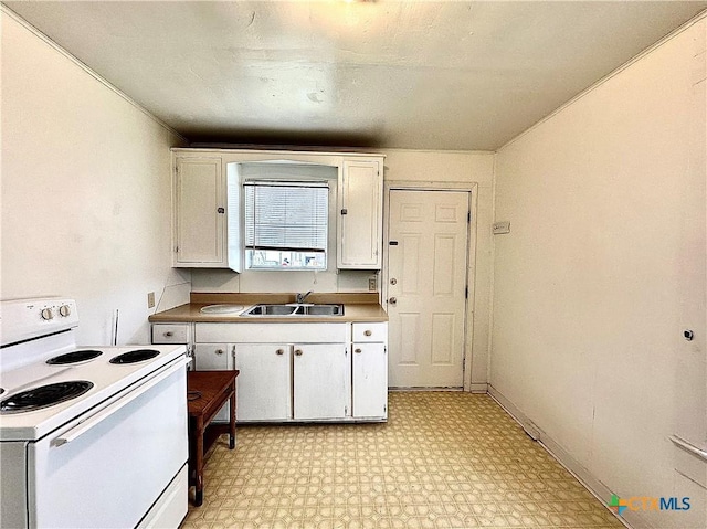 kitchen with light floors, white range with electric stovetop, white cabinetry, and a sink