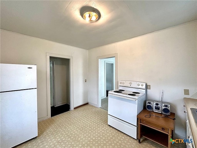 kitchen featuring white appliances, baseboards, and light floors