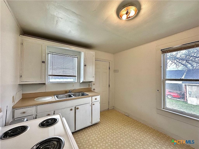 kitchen featuring a sink, white cabinetry, light countertops, light floors, and white range with electric cooktop