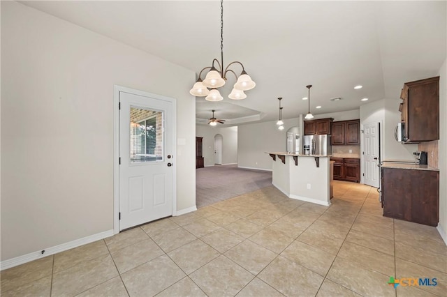 519 Gianotti Ct, Temple, TX 76502 - kitchen with stainless steel refrigerator with ice dispenser, open floor plan, a ceiling fan, a chandelier, and a breakfast bar area