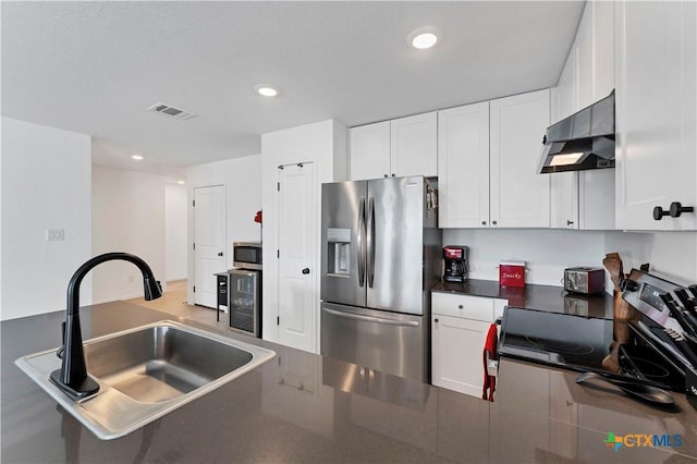 kitchen featuring visible vents, a sink, stainless steel appliances, dark countertops, and exhaust hood