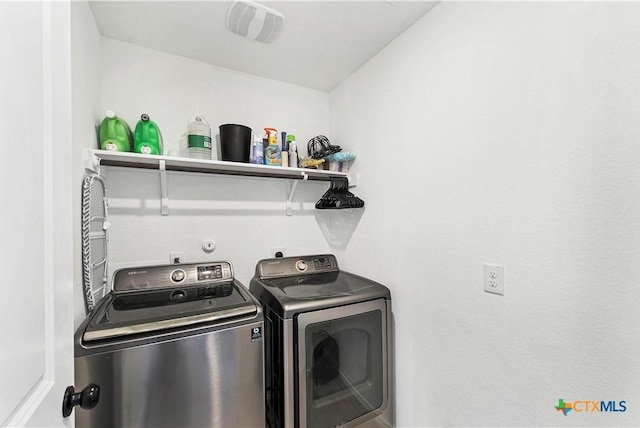 laundry area with laundry area, washing machine and dryer, and visible vents