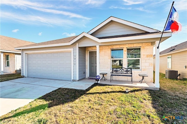 view of front of property featuring a front lawn, an attached garage, concrete driveway, and central AC