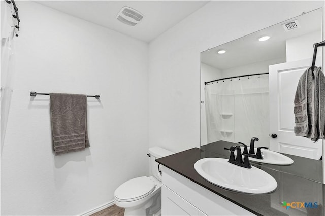 full bathroom featuring vanity, toilet, baseboards, and visible vents