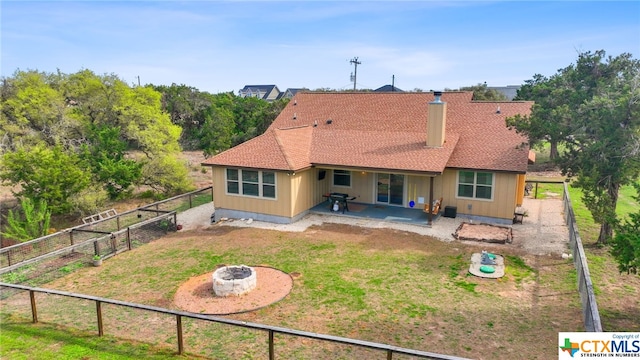 back of house featuring a patio area, a yard, and an outdoor fire pit