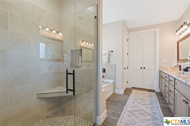 bathroom with vanity, hardwood / wood-style floors, and separate shower and tub