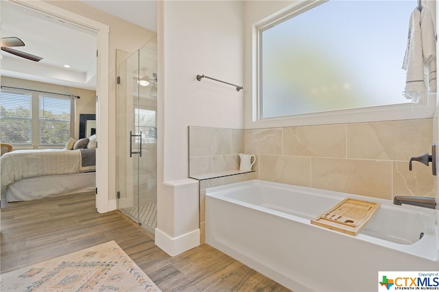 bathroom featuring hardwood / wood-style floors, ceiling fan, and plus walk in shower