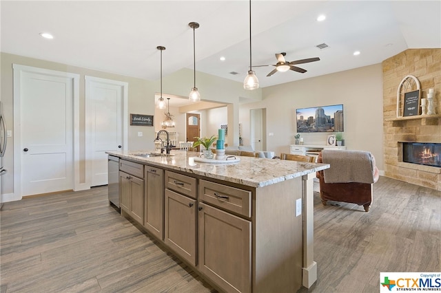 kitchen featuring sink, decorative light fixtures, a kitchen island with sink, dishwasher, and dark hardwood / wood-style flooring