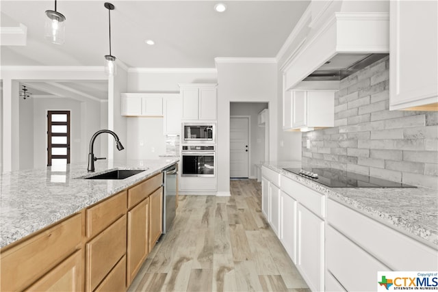 kitchen featuring stainless steel appliances, light hardwood / wood-style floors, white cabinetry, sink, and light brown cabinetry