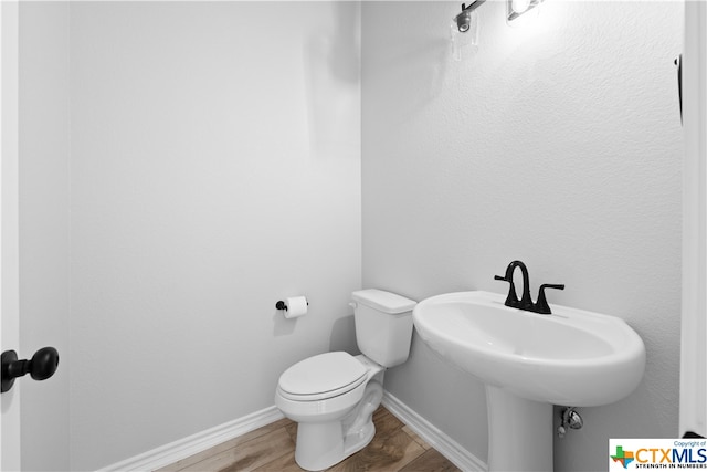 bathroom featuring hardwood / wood-style floors and toilet