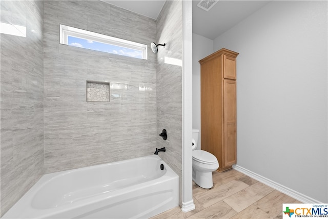 bathroom with tiled shower / bath and toilet